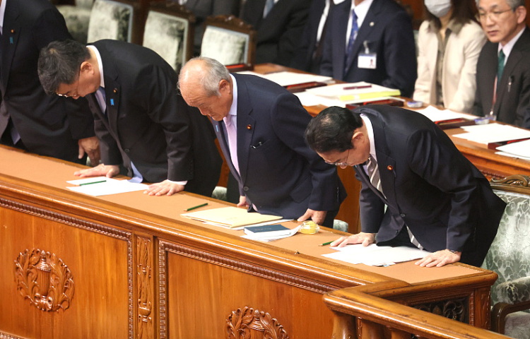 日本首相岸田文雄(右)和他的内阁成员低下了头